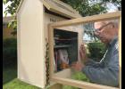 Chuck McMurray of Long Prairie shows off his free library located in his front yard. Book lovers are encouraged to come to the Little Free Library and take a book or share a book.