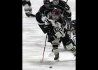 Hudson Pung was able to slip by a pair of Park Rapids defenders during Mid-State hockey action at the Expo Arena last Tuesday night.
