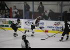Sophomore Cole Crosby carried the puck up the ice between a pair of defenders in Saturday’s win over Breckenridge/Wahpeton.