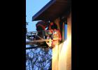 A member of the Long Prairie Fire Department helps a resident climb out of a window and down the ladder.
